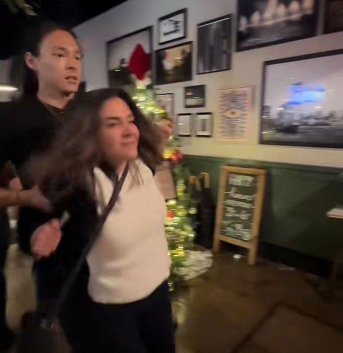 Bartender at San Francisco bar restraining a woman during viral incident, sparking outrage over firing and call for raise.