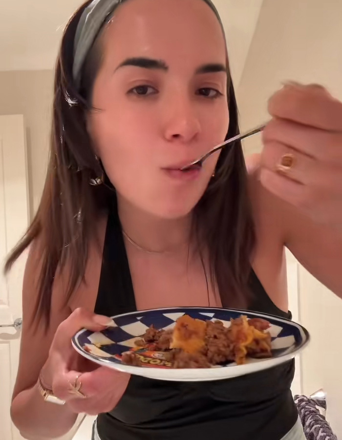 Woman enjoying a bite of food on a plate, reacting to a surprising Hinge match meal on first date. Woman enjoying a bite of food on a plate, reacting to a surprising Hinge match meal on first date.