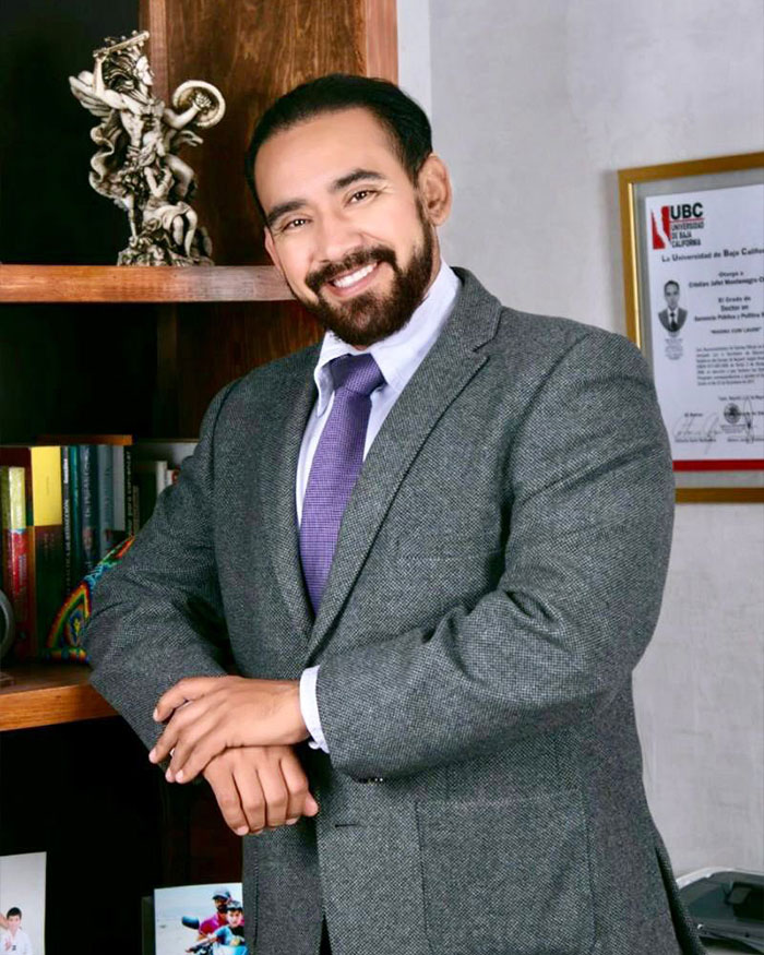Man in a gray suit smiling confidently, representing a father involved in a gender identity and child support controversy.