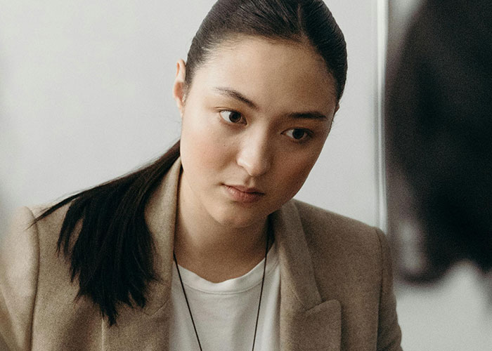 Young woman with a serious expression listening attentively, representing habits neurodivergent people thought were normal.