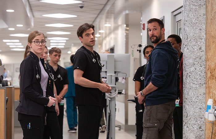 Noah Wyle with cast members in hospital hallway scene from The Pitt, starring in Season 2 of the medical drama series.