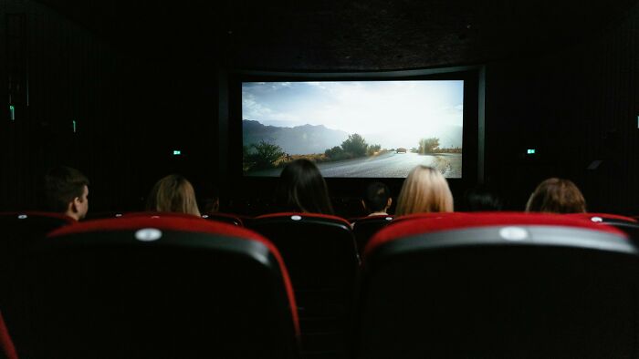 Audience watching a movie in a dark theater, casting votes on whether these people did the right thing.