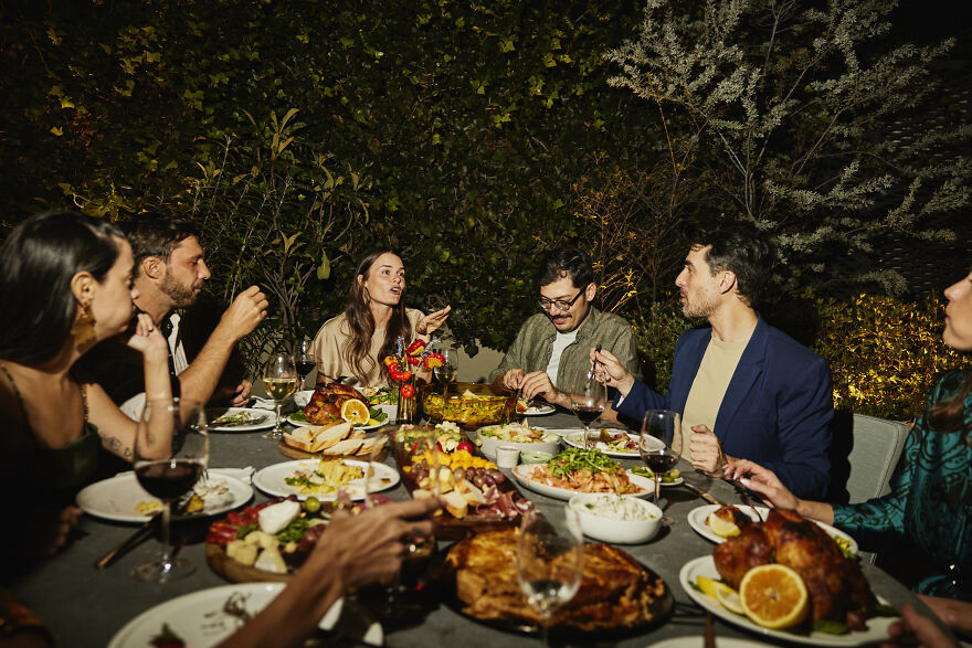 Group of friends talking and eating dinner outdoors at night, enjoying a lively paranoia questions gathering. Group of friends talking and eating dinner outdoors at night, enjoying a lively paranoia questions gathering.