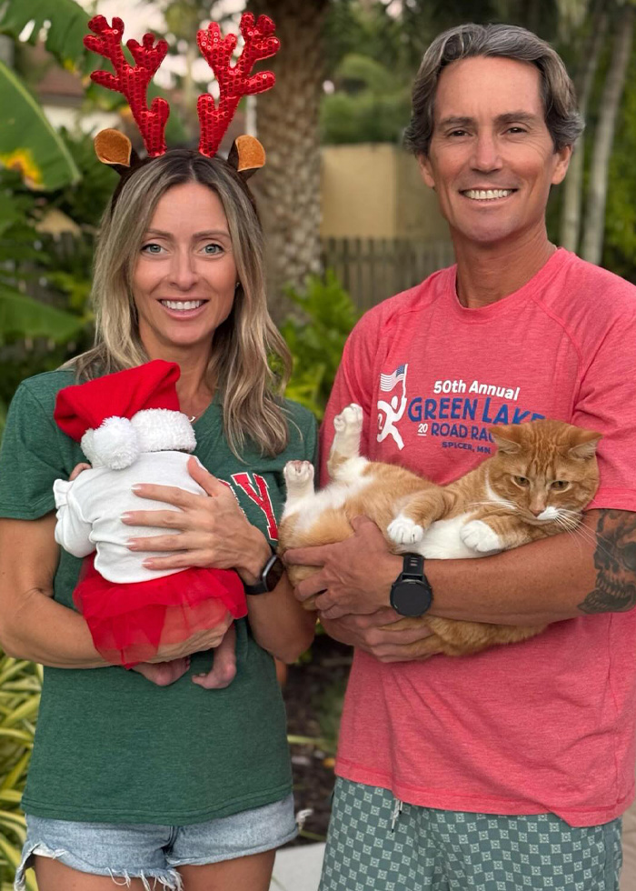 Couple holding baby and cat outdoors, representing parents suing fertility clinic over shocking mix-up. Couple holding baby and cat outdoors, representing parents suing fertility clinic over shocking mix-up.
