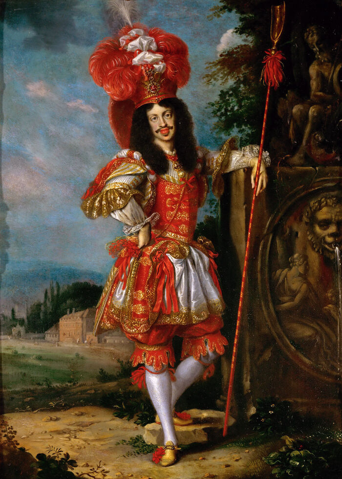 Medieval painting of a man in elaborate red and gold costume with feathered hat, holding a staff near a fountain sculpture.