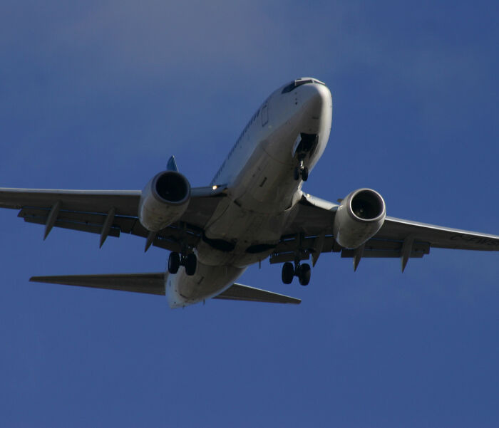 Underside of passenger jet approaching, illustrating sardine can seating on new planes Underside of passenger jet approaching, illustrating sardine can seating on new planes