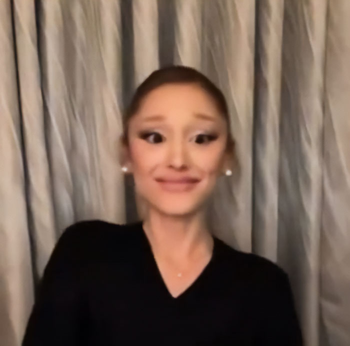 Ariana Grande making bizarre and unsettling facial expressions during a recent interview with a curtain background.