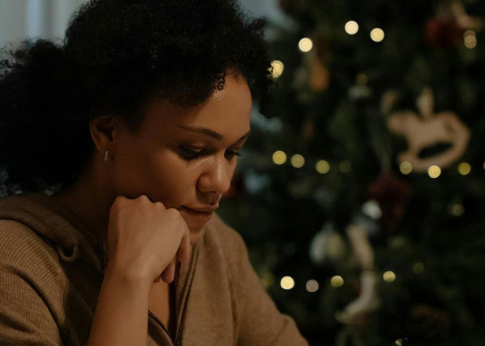 Woman feeling bad and ungrateful for gifts from husband, reflecting on the quality of his abhorrent presents at home.