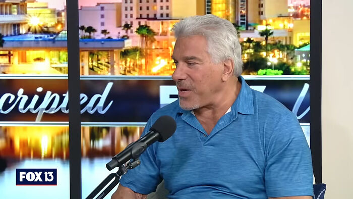 Man with gray hair in blue shirt speaking into microphone during FOX 13 interview about meeting idols in real life regrets
