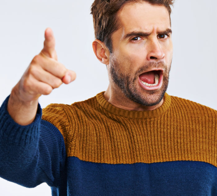 Angry man pointing and shouting, illustrating people realized friends or family were very weird