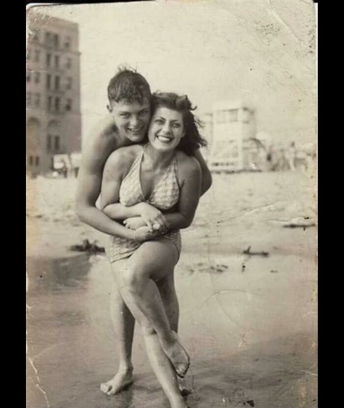 Vintage photograph of a happy couple at the beach, capturing a poignant moment in the history of humanity.