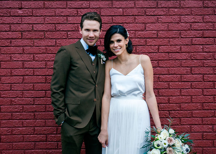 Couple posing in wedding attire against red brick wall, related to Ohio dentist homicide and FBI agent motive suggestion.