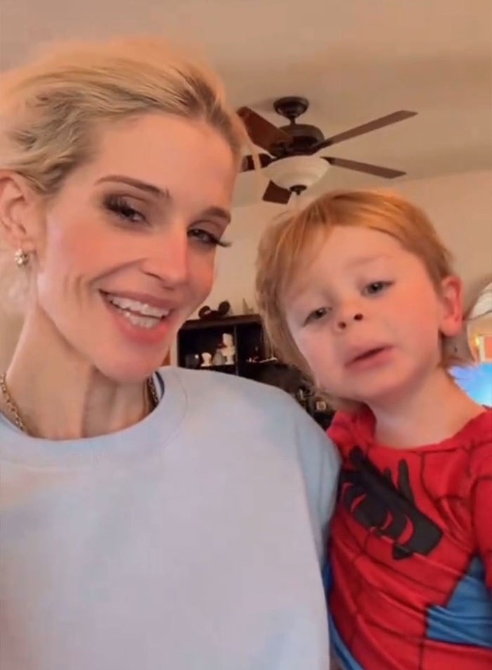 Kelly Osbourne smiling with young child in casual home setting fans urge her to seek help after recent video.