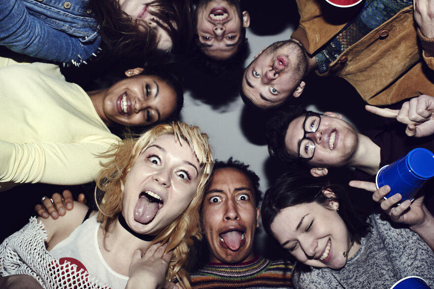 A group of friends gathering closely in a circle, making funny faces and sharing paranoia questions together. A group of friends gathering closely in a circle, making funny faces and sharing paranoia questions together.