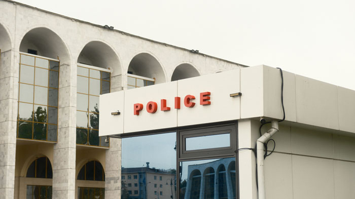 Exterior of a police station with reflections, related to a woman&rsquo;s story about her hair stylist and a strange hair shrine.