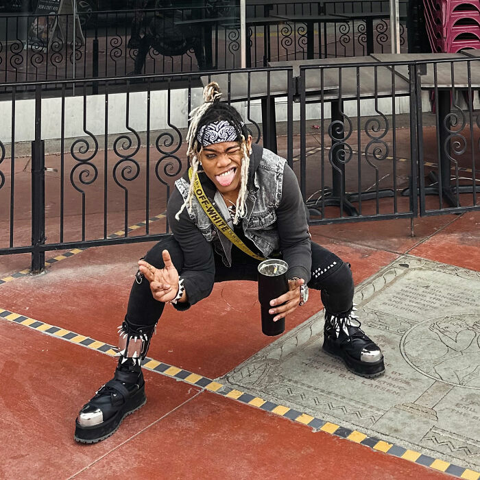 Young musician posing outdoors in edgy outfit, highlighting the controversy involving Will Smith accused of harassment and grooming.