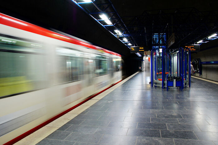 Blurred train passing through an empty underground station platform, illustrating weird and shocking public scenes without shame.