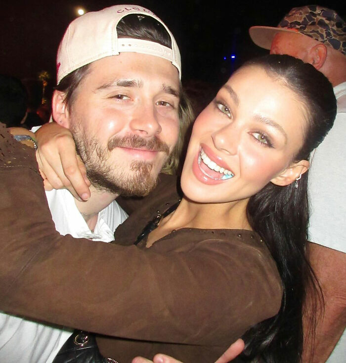 Brooklyn Beckham embraces a woman at a nighttime event amid rumors of a family feud involving his parents. Brooklyn Beckham embraces a woman at a nighttime event amid rumors of a family feud involving his parents.