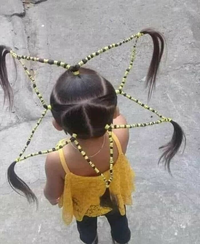 Child with a unique and intricate hairstyle featuring braided sections extending outward, a prime example of disastrous hairstyles.