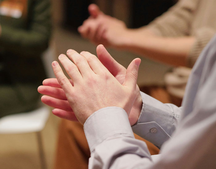 Close-up of hands clapping in a small group meeting, people reacting to weird friends.