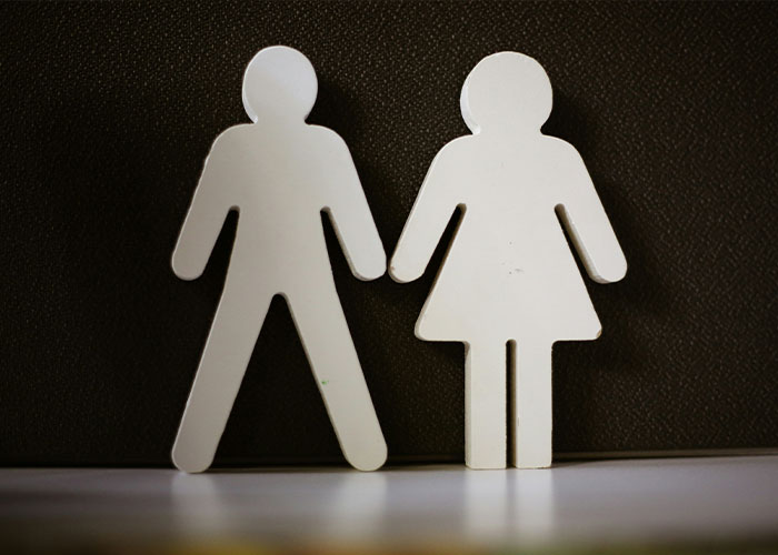 White paper cutouts of male and female figures side by side representing gender identity and child support issues.