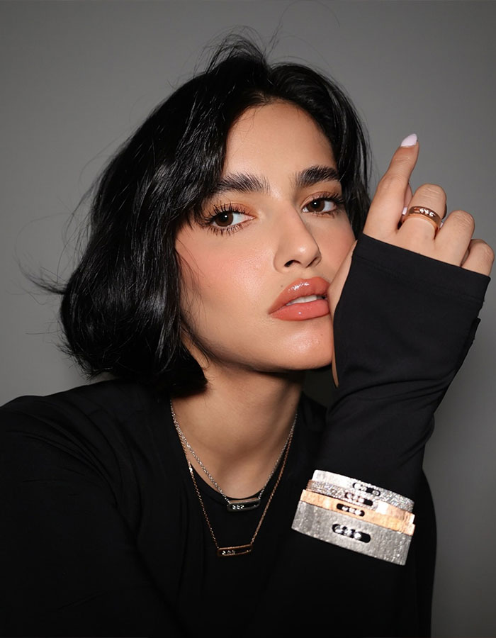 Close-up portrait of a woman with sleek black hair wearing stylish jewelry, linked to Selena Gomez plagiarism claims.