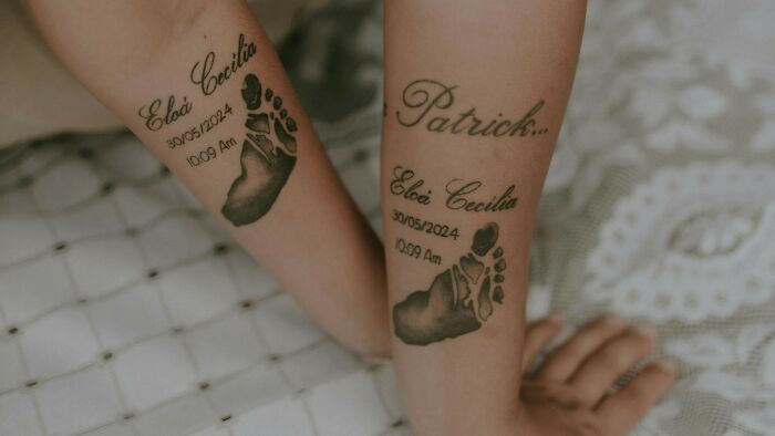 Matching tattoos on two forearms with footprints and names, symbolizing a meaningful and personal decision moment.