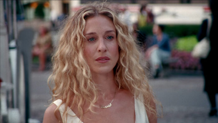 Actress with long curly blonde hair standing outdoors, representing celebs who weren’t nepo babies and achieved success independently.