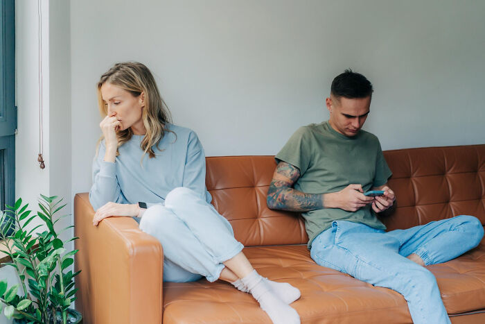 Couple sitting apart on a couch looking upset, illustrating the fastest times couples said I do and I'm done.