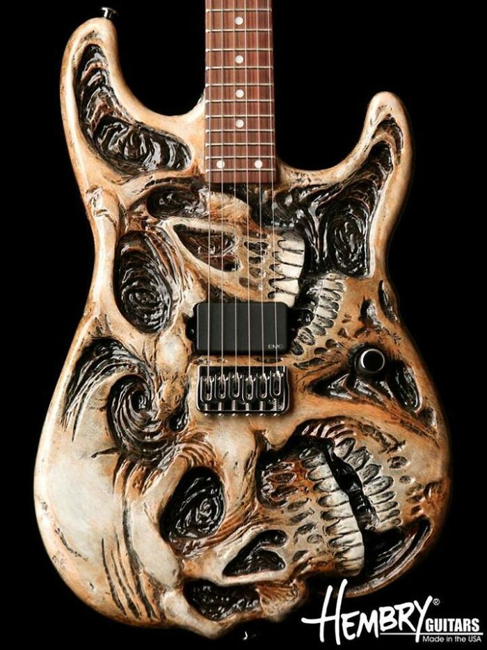 Handcrafted wooden electric guitar with skull-themed carving showcasing impressive woodworking projects.