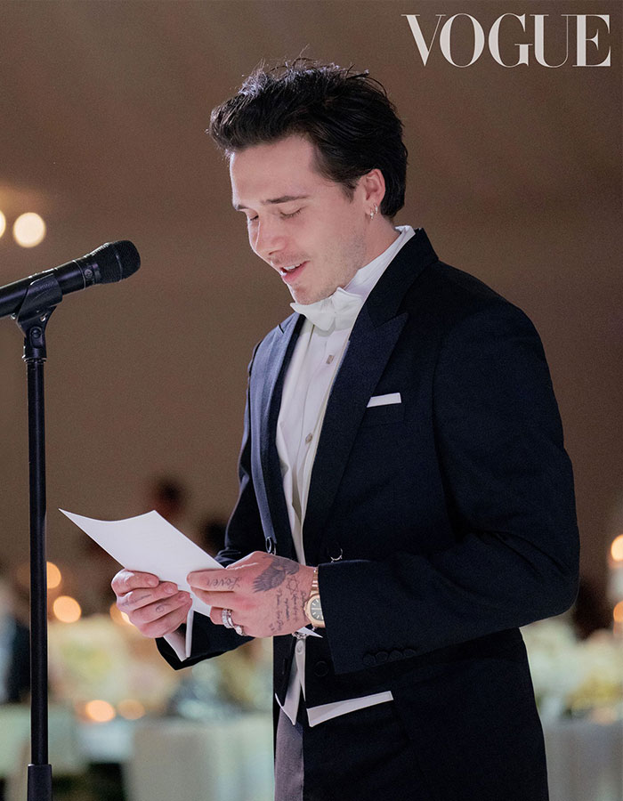 Man in a tuxedo reading a speech at a wedding reception, related to Victoria Beckham inappropriate dance details.