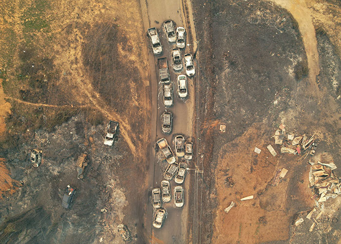 Aerial view of burned vehicles and scorched land showing chaos after Chile wildfires devastated the town overnight.