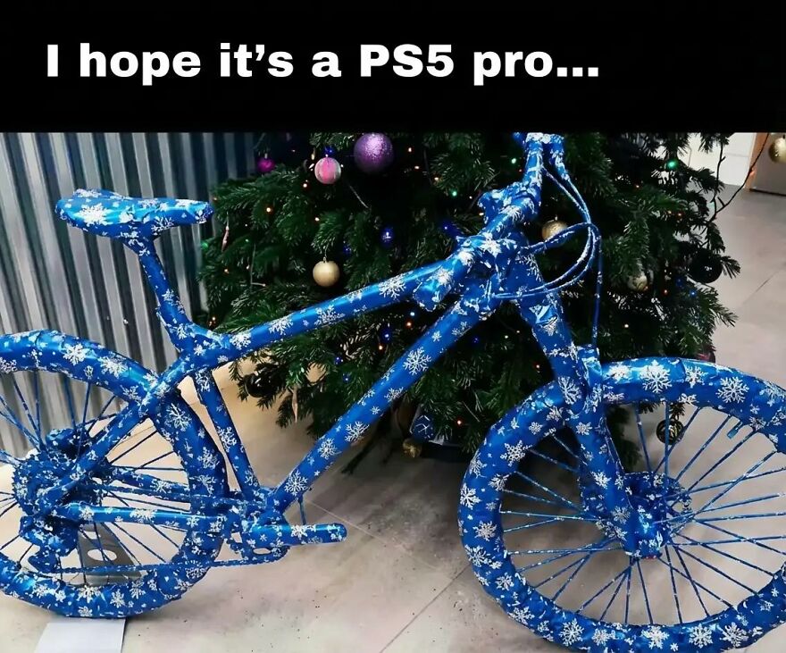 Bicycle wrapped like a gift with snowflake paper near a Christmas tree, relatable meme for exhausted adults wanting video games.