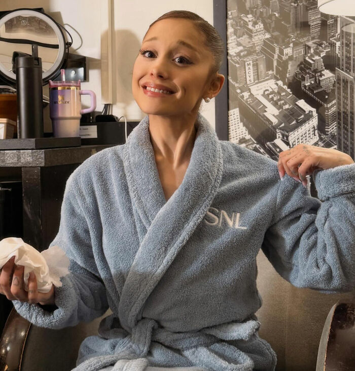 Ariana Grande in a blue SNL robe with a peculiar expression, sparking theories about her bizarre mannerisms. Ariana Grande in a blue SNL robe with a peculiar expression, sparking theories about her bizarre mannerisms.