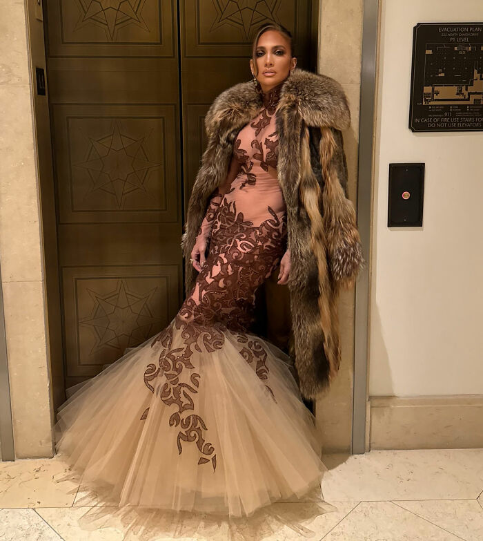 Jennifer Lopez wearing a detailed gown and fur coat, linked to a rude interaction sparking Golden Globes backlash.