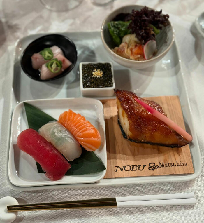 Assorted sushi and grilled fish served on a tray showcasing Golden Globes food available to order on DoorDash.