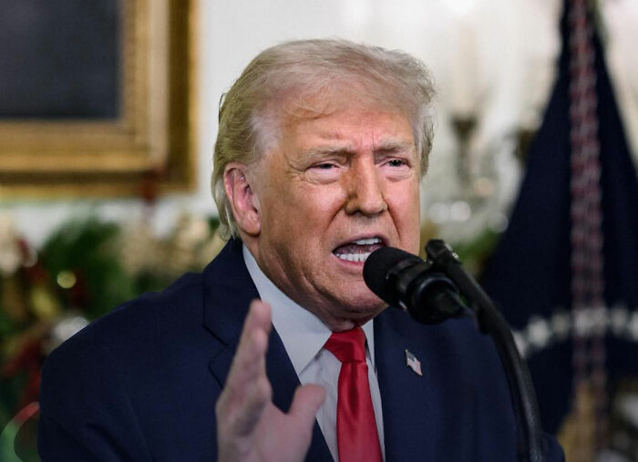 Former President speaking at Mar-a-Lago event with controversial costumes and dog masks in a creepy setting. Former President speaking at Mar-a-Lago event with controversial costumes and dog masks in a creepy setting.