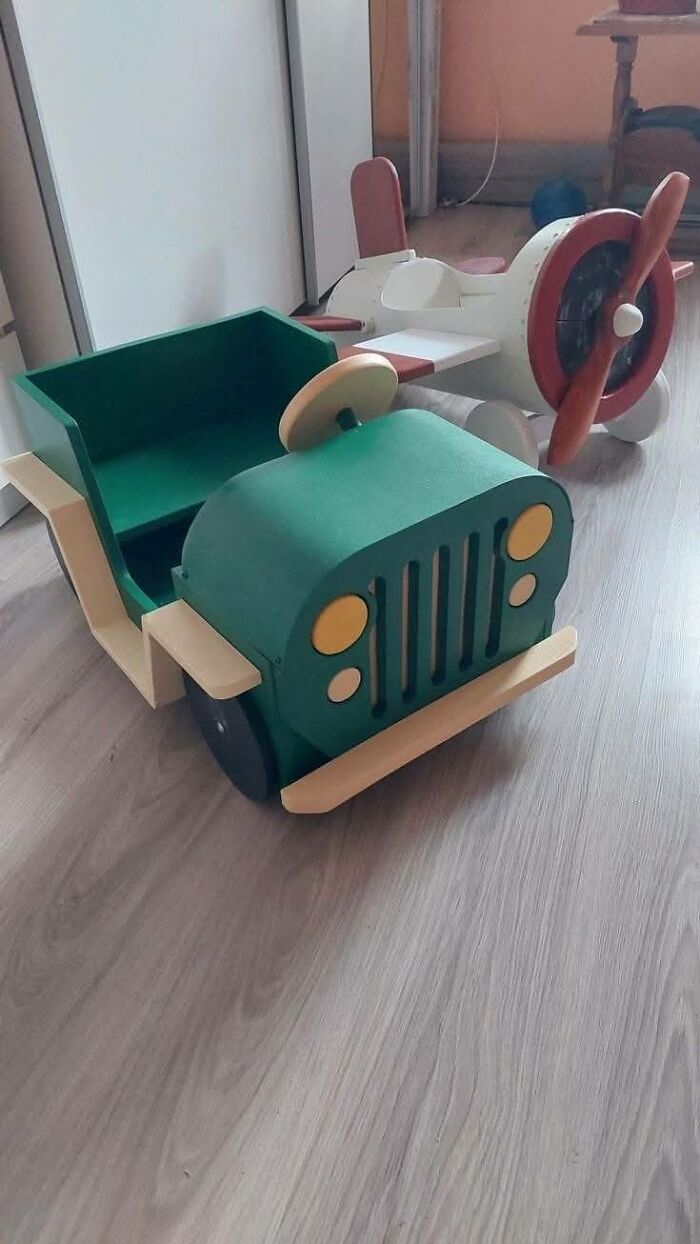 Wooden toy jeep and airplane crafted woodworking projects displayed on a light wood floor in a room.