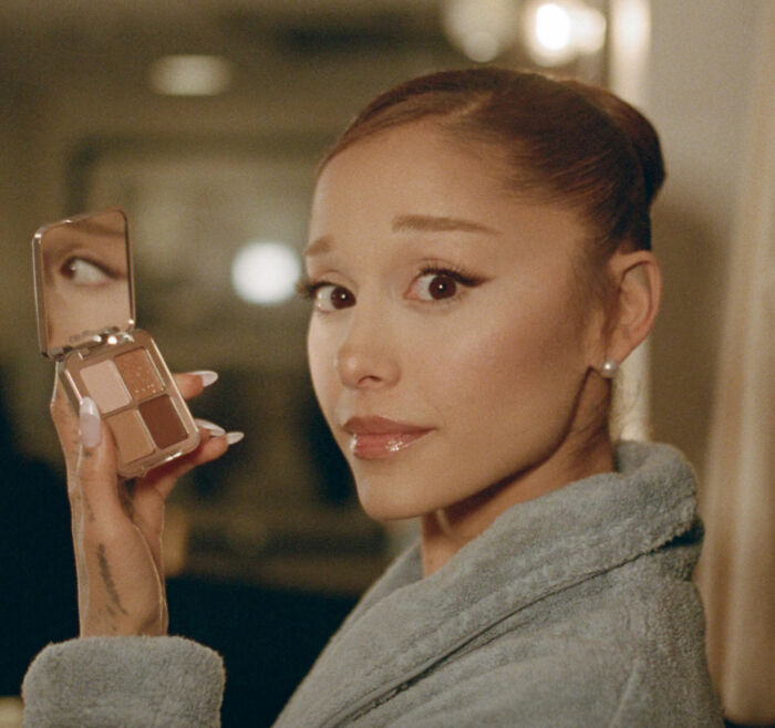 Ariana Grande holding a makeup palette, showcasing her bizarre mannerisms in a recent unsettling interview. Ariana Grande holding a makeup palette, showcasing her bizarre mannerisms in a recent unsettling interview.