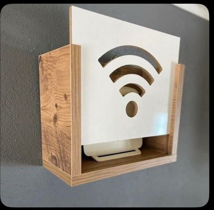 Woodworking project of a wall-mounted wooden box with a Wi-Fi symbol cutout for router storage and decoration.