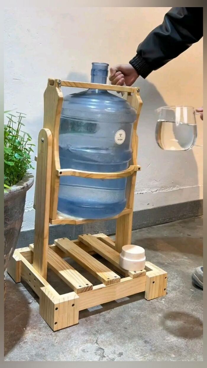 Woodworking project featuring a handmade wooden water dispenser stand holding a large water jug.