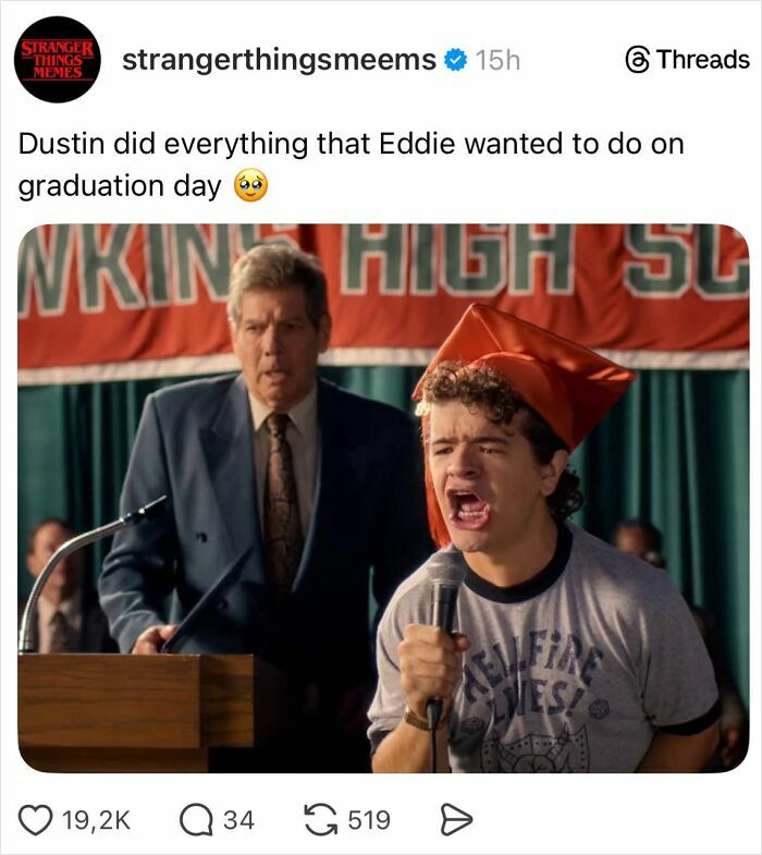 Stranger Things graduation scene showing Dustin in a cap and gown speaking into a microphone with a man at a podium behind him.