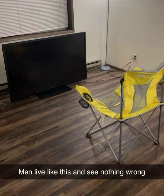 Minimalist living room setup with a TV on the floor and a yellow chair, showing sibling life fun and simplicity.
