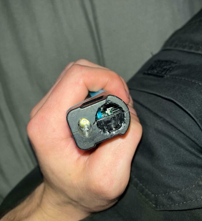 Hand holding a mangled vape battery with exposed wiring and melted plastic, showing next-level jerks