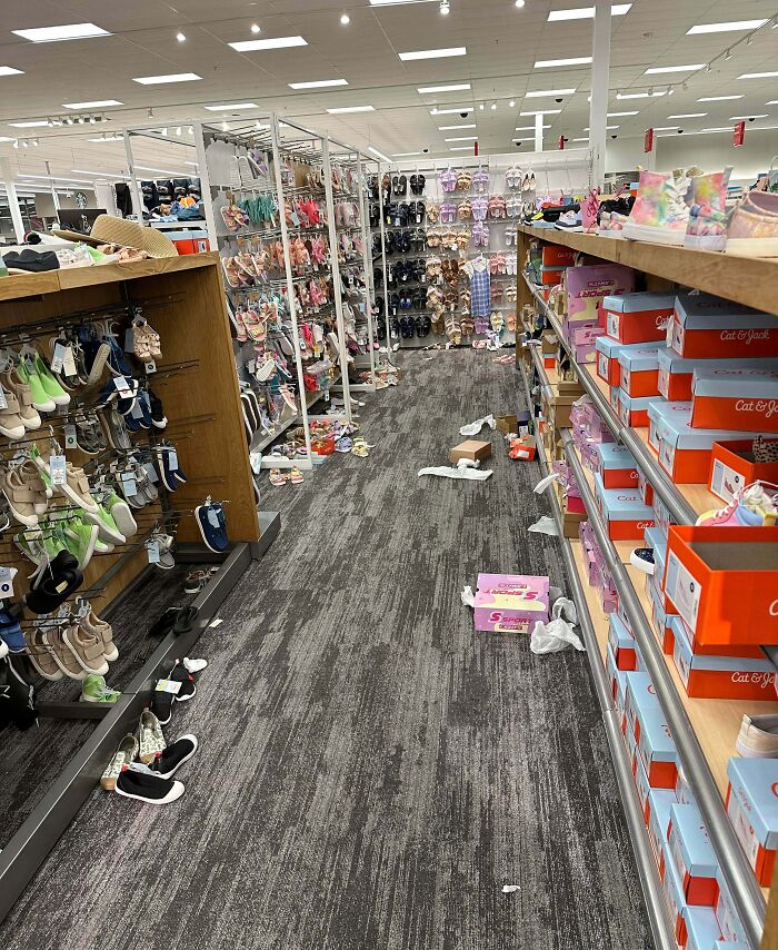Messy shoe aisle with scattered boxes, loose shoes and trash left on floor by next-level jerks
