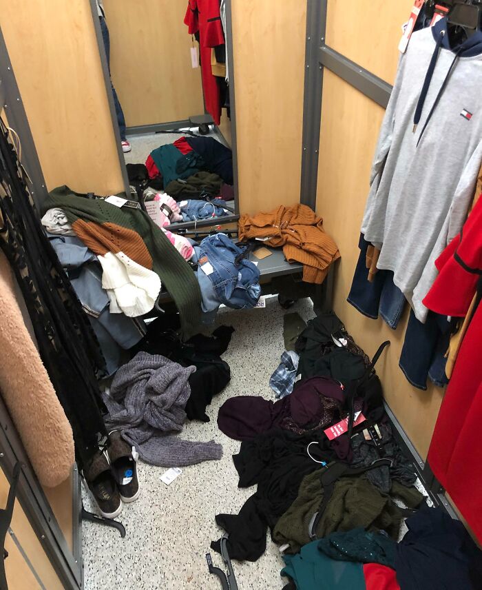 Clothing store dressing room trashed with clothes and shoes scattered on floor, showing next-level jerks' behavior