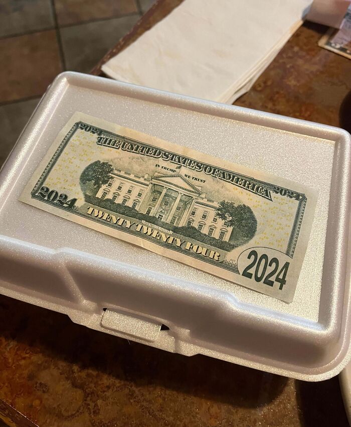 Styrofoam takeout container with a novelty 2024 twenty bill on top, a prank by next-level jerks