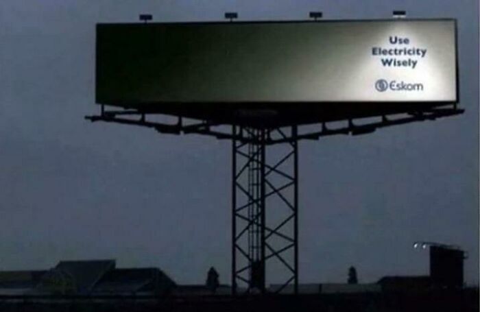 Billboard print advertisement creatively uses partial lighting to emphasize the message about using electricity wisely.