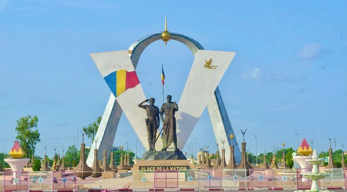 Most Stressful Countries: large national arch monument with two statues, flag and fountain under bright blue sky