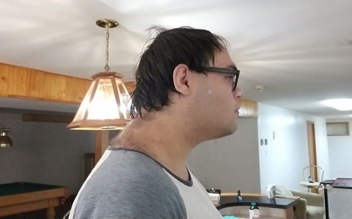 Side profile of a tall person with glasses in a home setting, highlighting common struggles only tall people face.